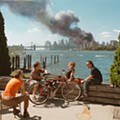 USA. Brooklyn, New York. September 11, 2001. Young people relax during their lunch break along the East River while a huge plume of smoke rises from Lower Manhattan after the attack on the World Trade Center.jpg